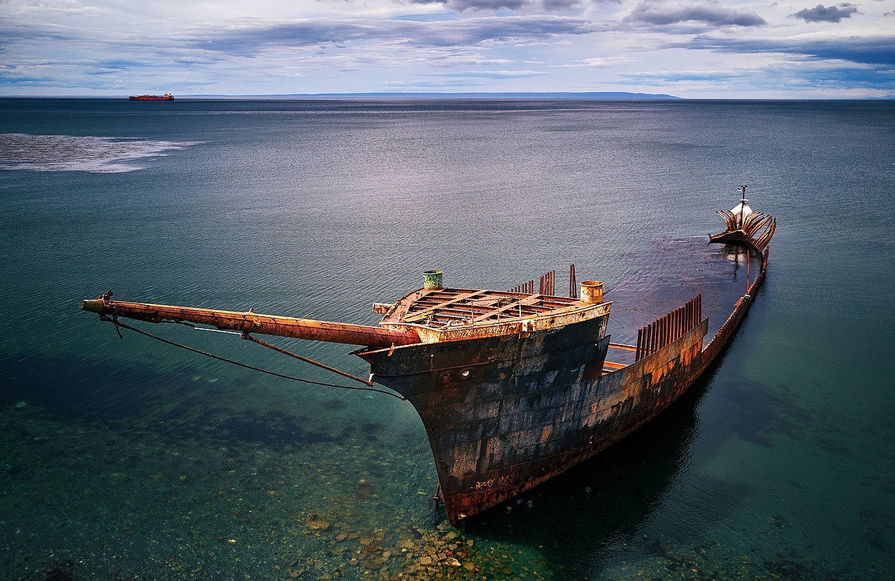beautifully shaped partially submerged lord lonsdale ship in the foreground of the photo with green water and cloudy sky in the background