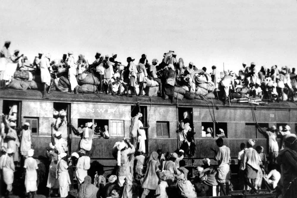 Muslim refugees clamber aboard an over-crowded train near New Delhi in an attempt to flee India