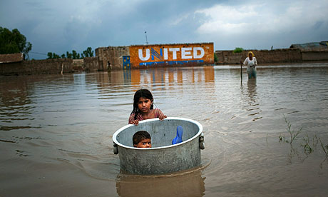 A girl floats her brother across flood waters whilst salvaging valuables from their flood ravaged home in the village of Bux Seelro near to Sukkur, Pakistan.