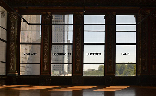 photo of windows with text reading you are on un-ceded land