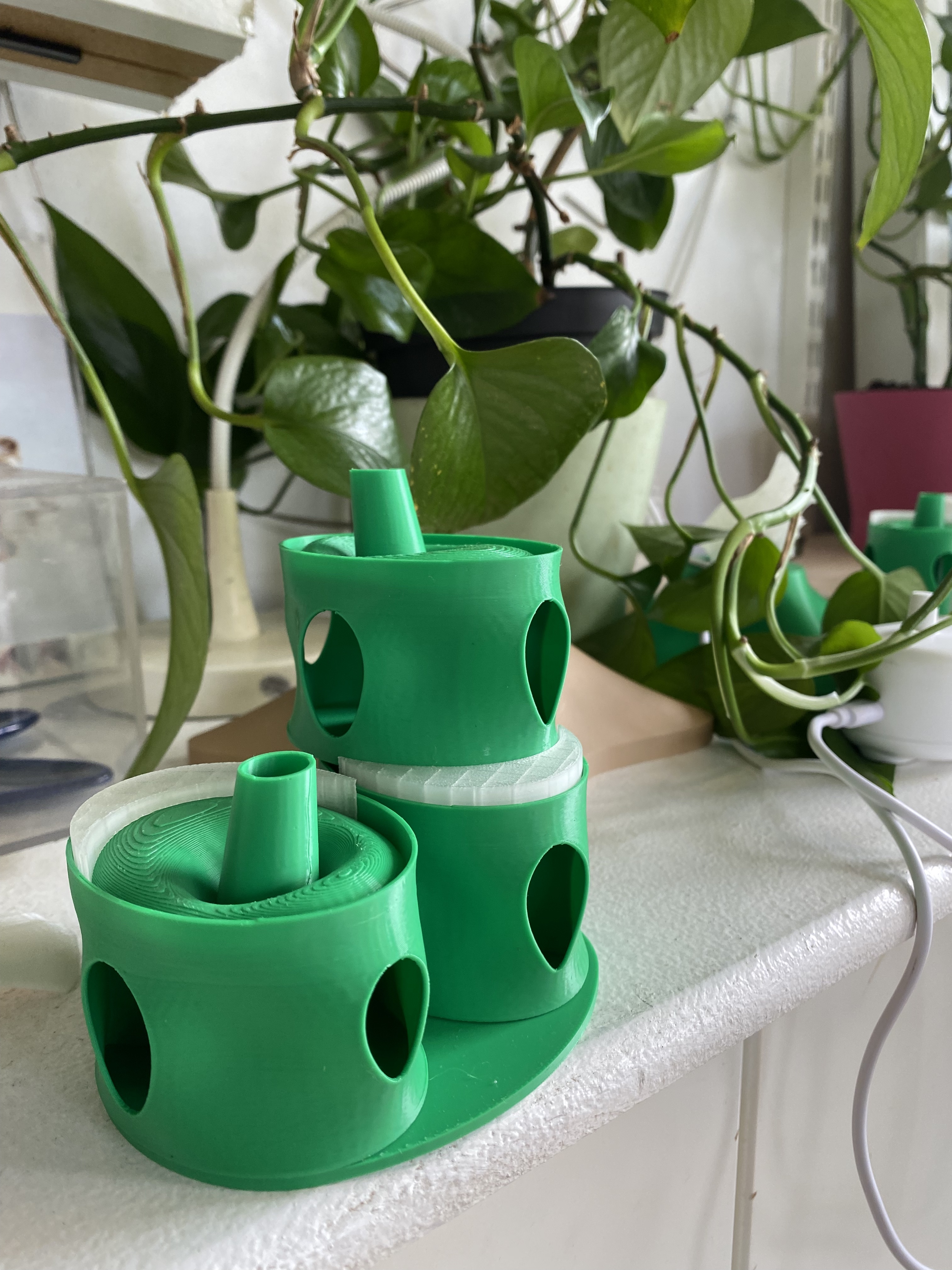 Approximately 1 inch high, green, 3D printed pods modeling a possible home for birds.