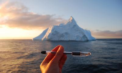 iceberg with hand and penn in foreground